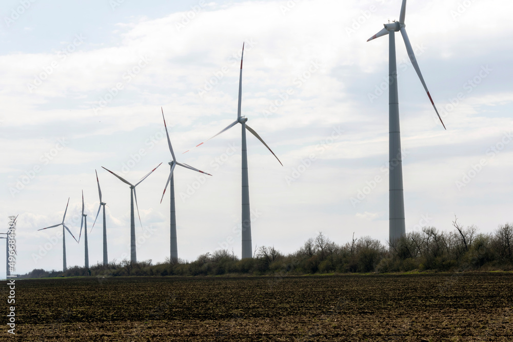 The wind farm consists of several picturesque wind turbines. Green energy in action. Renewable energy. The wind farm consists of several picturesque wind turbines. Green energy in action. Renewable energy.