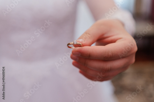 Golden wedding ring in the hands of the bride