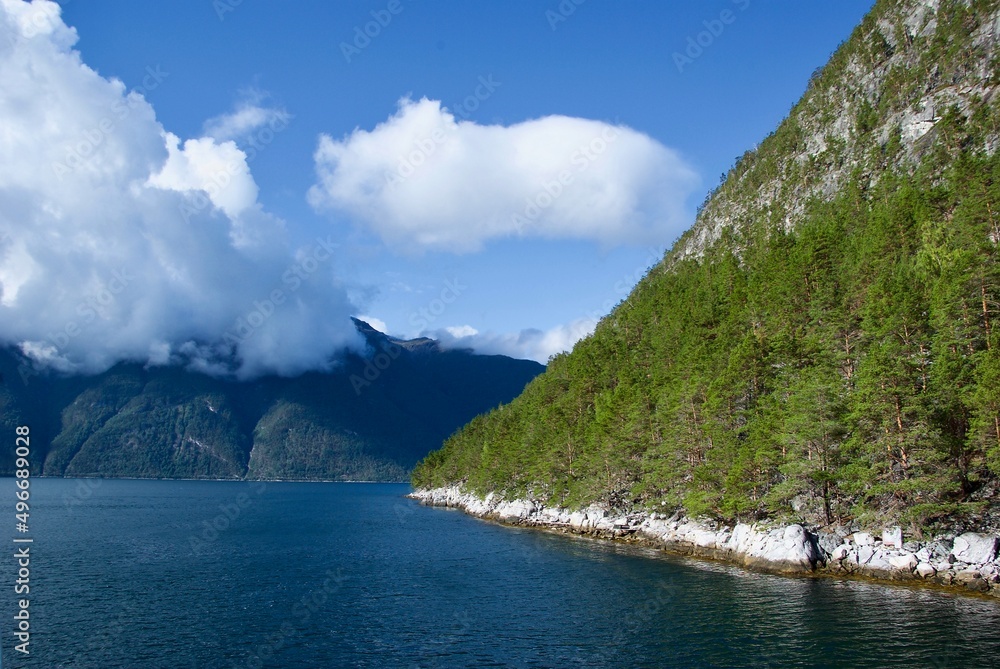 Mountains and clear blue sky with clouds in summer in Sognefjorden in Sogn og Fjordane fylke in Norway.