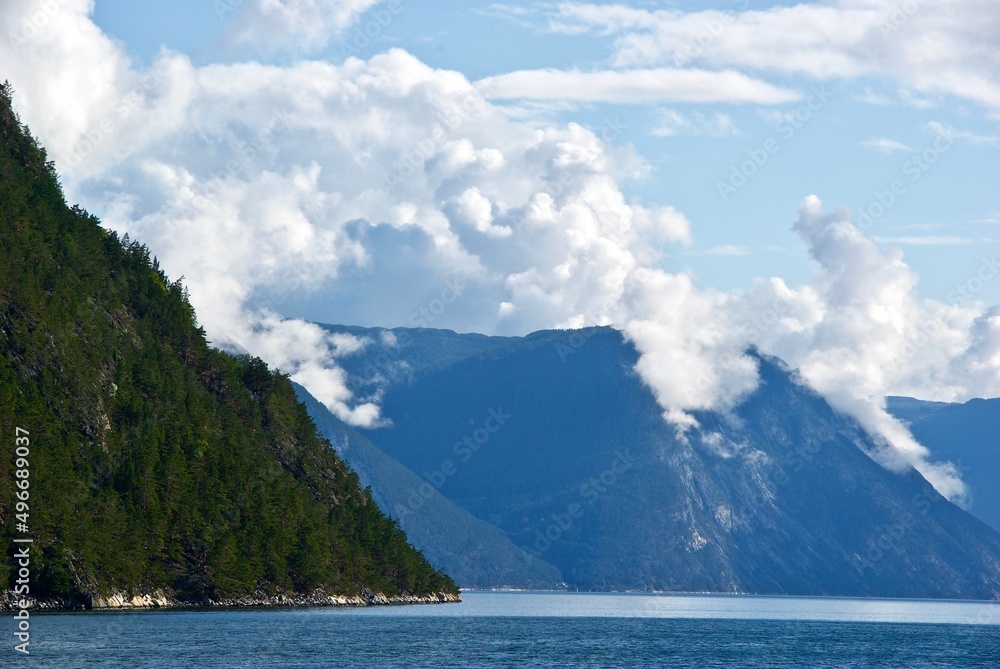 Mountains and blue sky with clouds in summer in Sognefjorden in Sogn og Fjordane fylke in Norway.