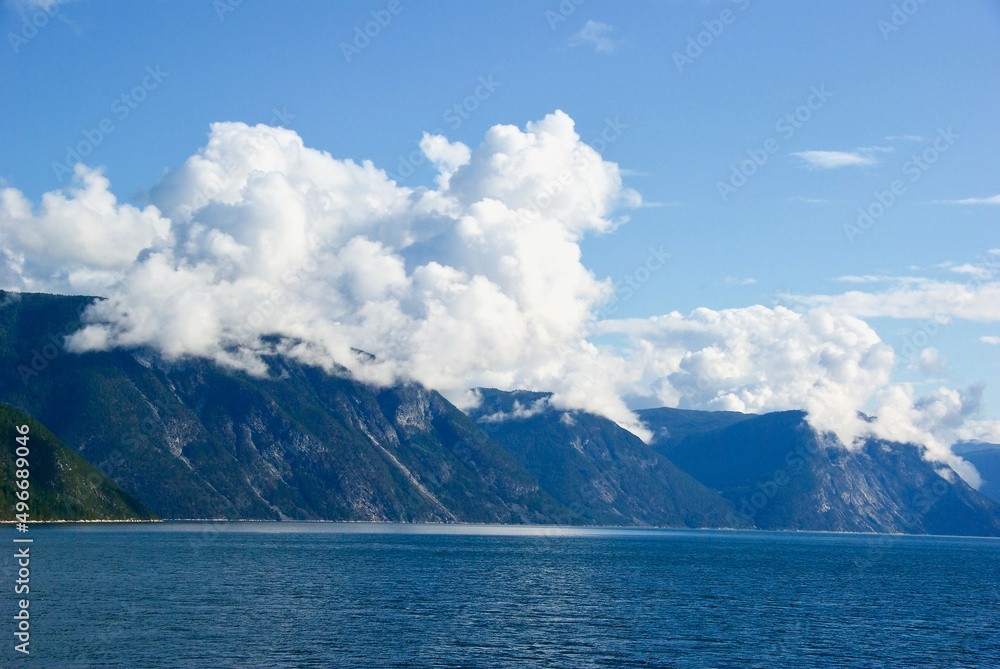Mountains and blue sky with clouds in summer in Sognefjorden in Sogn og Fjordane fylke in Norway.