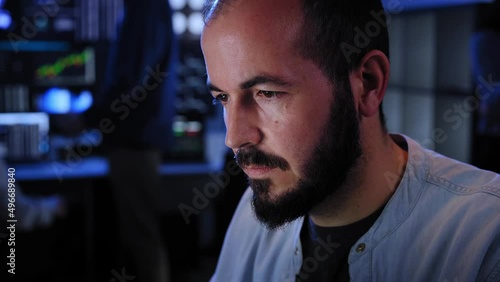 Team of stockbrokers are having a conversation in a dark office with display screens. Professional IT Technical Support Specialist Working on Computer Monitoring Server Data, Blockchain Network photo