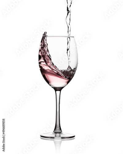 Pink wine pouring into a glass making a splash. White background