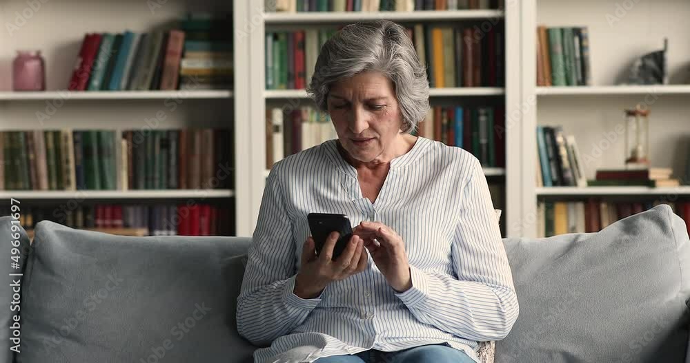 Happy middle-aged woman sit on sofa holds smartphone read massage celebrate great, fantastic news feels overjoyed looks excited, auction jackpot win, success and achievement, moment of victory concept Happy middle-aged woman sit on sofa holds smartphone read massage celebrate great, fantastic news feels overjoyed looks excited, auction jackpot win, success and achievement, moment of victory concept