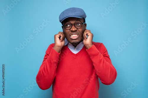 Young african man plugging ears with fingers
