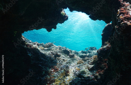 Underwater cave exit in the ocean with sunlight through water surface, south Pacific, Polynesia