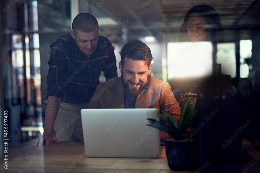 This is an exciting project so far. Shot of a group of work colleagues working together on a laptop and exchanging ideas in the office. This is an exciting project so far. Shot of a group of work colleagues working together on a laptop and exchanging ideas in the office.