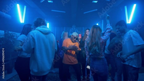 Wallpaper Mural An African-American man dances in a crowd in a nightclub on the dance floor under the light of colored spotlights. Night club Torontodigital.ca