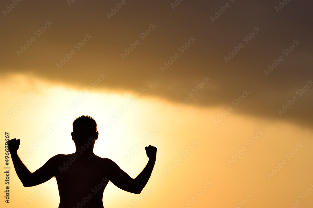 Man posing with strength posture with copy space at sunset