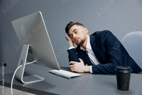 a man in a suit drinking coffee tired at work with documents on the table executive