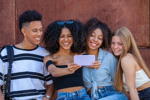 diverse group teens taking selfie with mobil phone photo