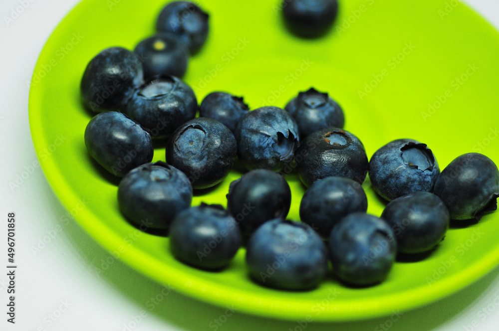Blueberries on a plate on a white background. Signs. Healthy wholesome food. Vitamins and microelements. Blueberries on a plate on a white background. Signs. Healthy wholesome food. Vitamins and microelements.