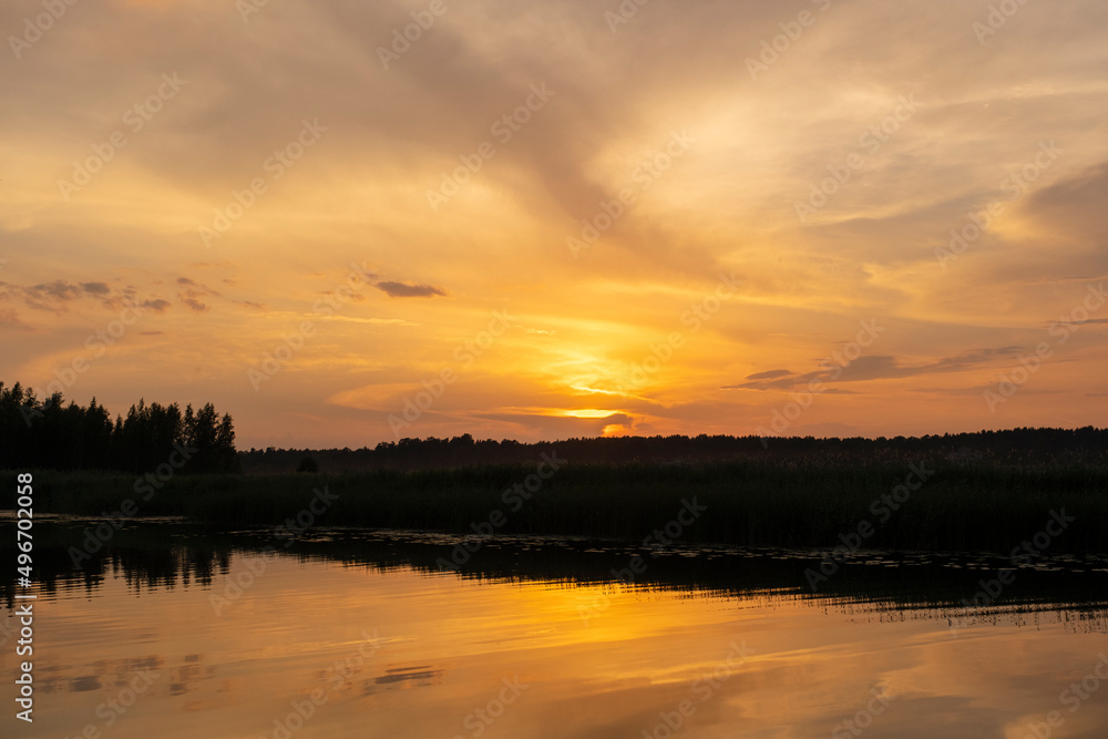 Lielupe River at sunset. Latvia. Bright, colorful sky, orange, yellow, golden colors of clouds. Lielupe River at sunset. Latvia. Bright, colorful sky, orange, yellow, golden colors of clouds.