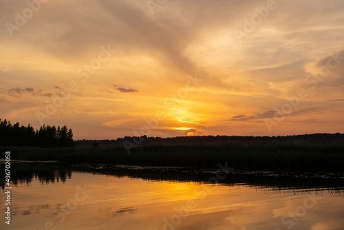 Lielupe River at sunset. Latvia. Bright, colorful sky, orange, yellow, golden colors of clouds.