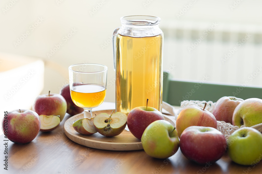 Fresh homemade organic apple juice or cider on a wooden table in a glass jug Fresh homemade organic apple juice or cider on a wooden table in a glass jug
