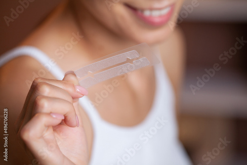 Beautiful Young Girl With White Teeth Holding in Hands Stripes For Teeth Whitening