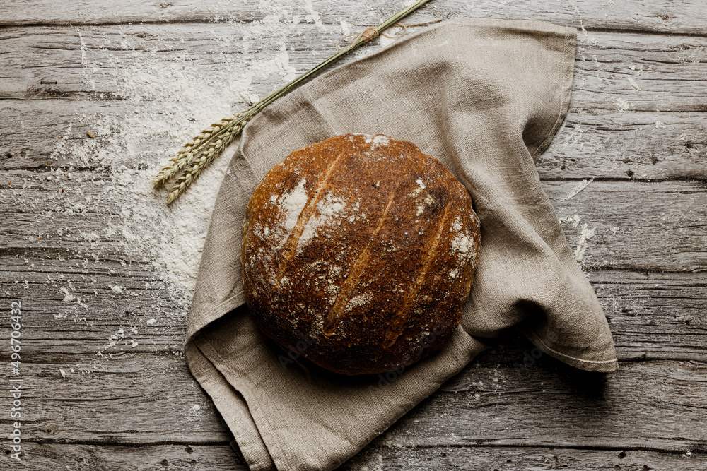 an artisan bread seen from the zenith on a rustic cloth on a rustic wooden table an artisan bread seen from the zenith on a rustic cloth on a rustic wooden table