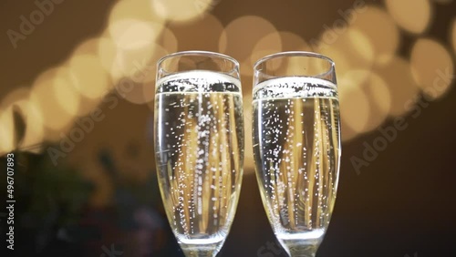 Two glasses with sparkling champaign with bubbles stand on the soft background