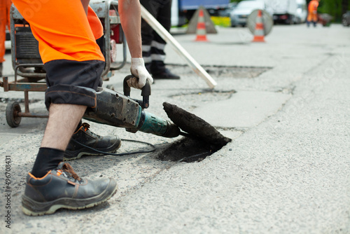 He removes the asphalt with a jackhammer. Removing the asphalt layer from the road.