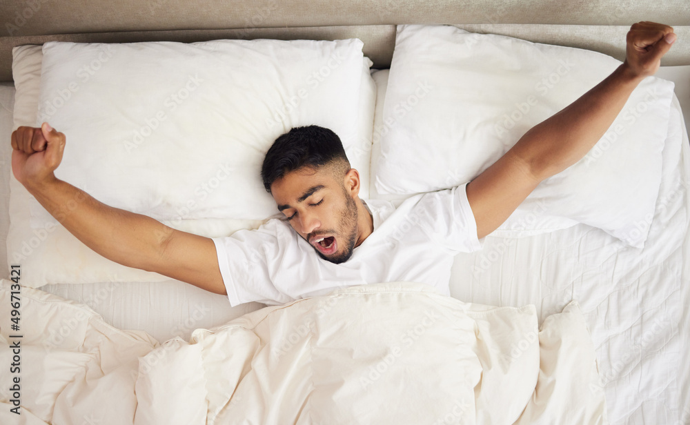 My pillow gives me a new hairstyle every morning. Shot of a young man waking up in a bed at home. My pillow gives me a new hairstyle every morning. Shot of a young man waking up in a bed at home.