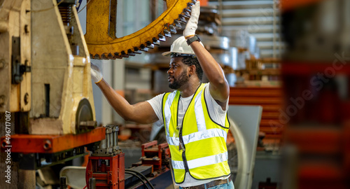 Konstfotografi African American mechanic worker is checking the gear for hydraulic machine insi