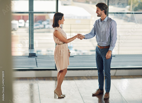 I cant wait to get started. Full length shot of two businesspeople shaking hands in the office.