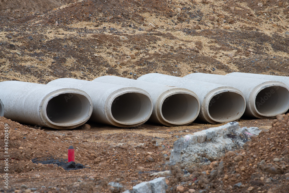 Reinforced concrete storm sewer pipes stacked at a construction site large diameter pipes