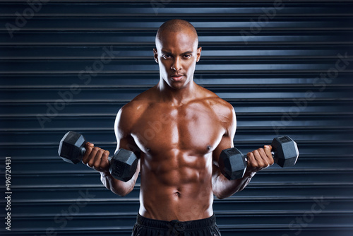 Make persistence a habit. Shot of a sporty young man working out with dumbbells as part of his exercise routine.