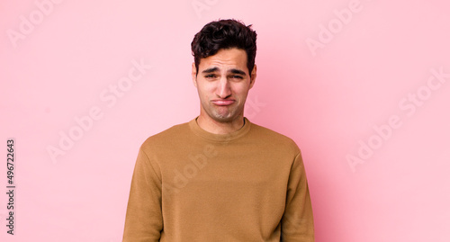 Fotografiet handsome hispanic man feeling sad and whiney with an unhappy look, crying with a