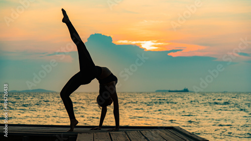 silhouette of a woman doing yoga on the beach. silhouette of a woman doing yoga.
