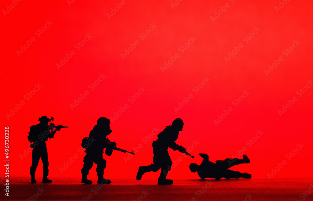 Silhouetted toy army plastic soldiers organised with a red background, war image