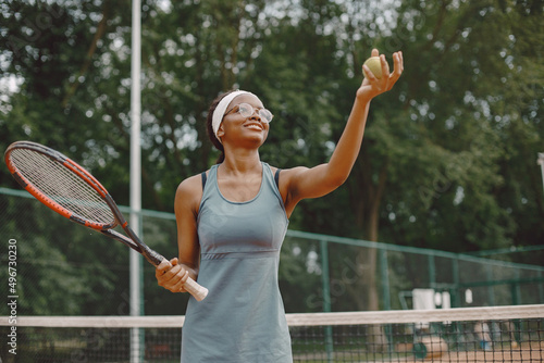 Black american female tennis player playing on the court outdoors © prostooleh