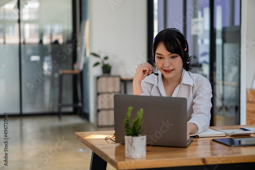 Asian female students wear headphones to learn languages online. watch and listen to the teacher Video call webinars e-learning at home concepts distance education girl looking at laptop screen © ArLawKa