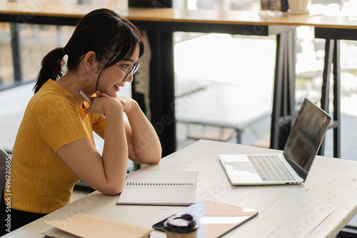 Asian women Work on laptops, computers, and tiger skins at the desk. Small business owners, employees, online, freelance, SME marketing, eCommerce, finance, office marketing ideas.