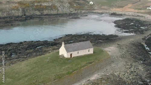 An aerial view of Eglwys Cwyfan church on an overcast day, flying right to left around the church, Anglesey, North Wales, UK photo