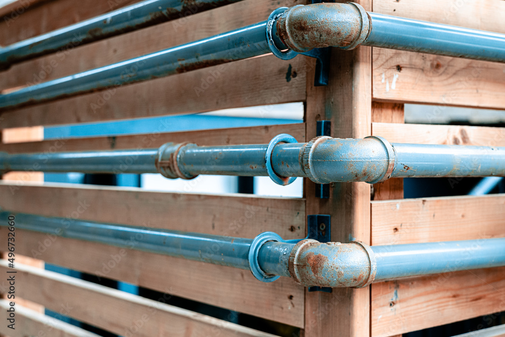 Blue pipes attached to wooden fence
