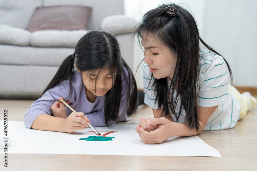 Mother teaches child to paint and paint in the living room. Good times together of single moms. Learn the arts and be together for a happy time. Mother teaches child to paint and paint in the living room. Good times together of single moms. Learn the arts and be together for a happy time.