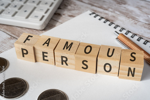 「FAMOUS PERSON」と書かれた積み木、ノート、ペン、電卓、コイン