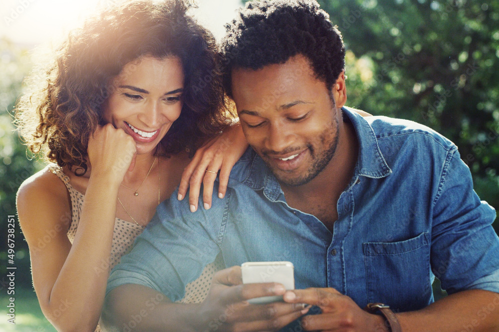 We both look good in this picture actually. Shot of an affectionate young couple using a cellphone together while relaxing outdoors. We both look good in this picture actually. Shot of an affectionate young couple using a cellphone together while relaxing outdoors.