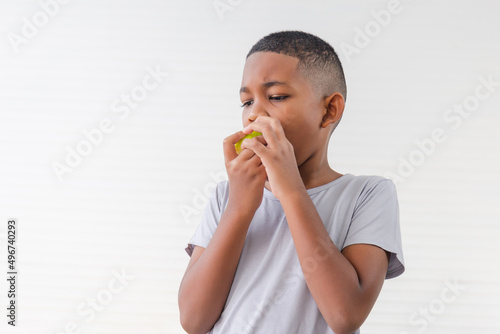 Child kid eating green apple fruit, Child playing and eating an apple in white wall living room