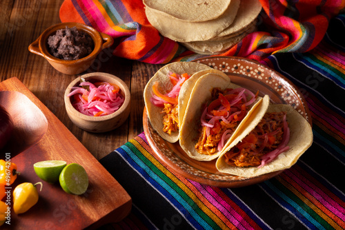 Tacos de Cochinita Pibil. Typical Mexican stew from Yucatan, made from pork marinated with achiote and generally accompanied with beans and red onion with habanero chili photo