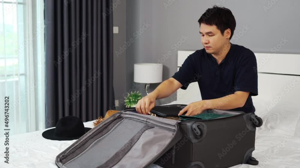 man packing clothes and close the suitcase on bed at home, holiday travel concept
man packing clothes and close the suitcase on bed at home, holiday travel concept