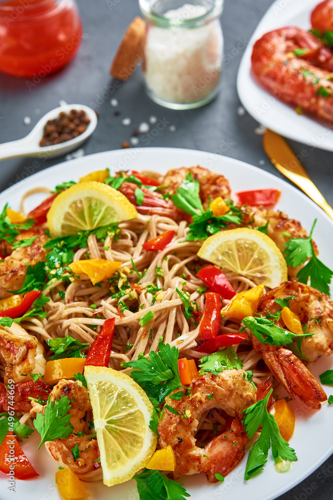 Stir fry noodle with shrimps, lemon and fresh parsley on white plate, soba with prawns, asian cuisine, top view Stir fry noodle with shrimps, lemon and fresh parsley on white plate, soba with prawns, asian cuisine, top view