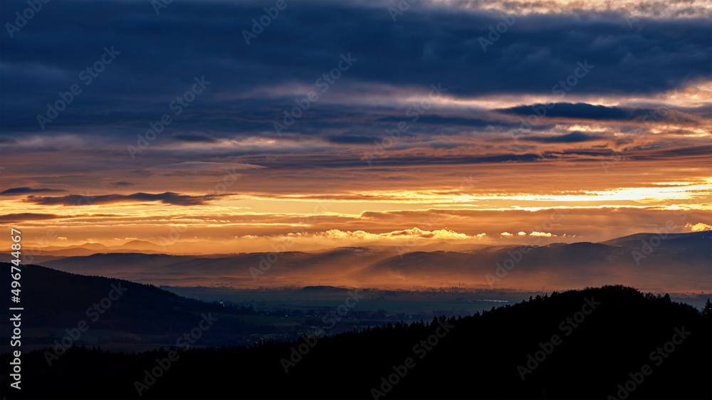 Fototapeta premium Sunset with dramatic cloudy sky over mountains shape, beautiful nature landscape