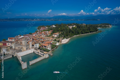 Aerial view on Sirmione sul Garda. Italy, Lombardy. Rocca Scaligera Castle in Sirmione. Boat with tourists near the main castle. View by Drone.