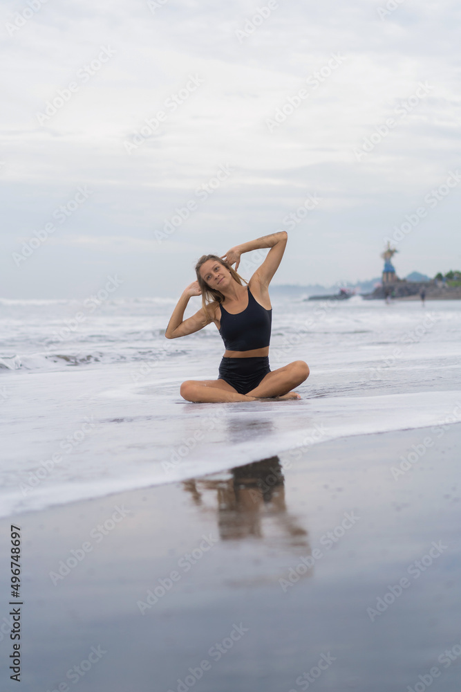 Sporty woman doing mountain climber exercise - run in plank to burn fat. Sunset beach, blue sky background. Healthy lifestyle at tropical island yoga retreat, outdoor activity, family summer vacation.