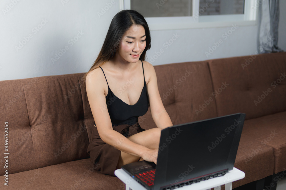 Sexy asian women sitting on the sofa working with a notebook, concept work from home. Sexy asian women sitting on the sofa working with a notebook, concept work from home.
