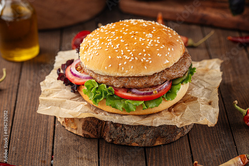 Fresh appetizing burger on the wooden background
