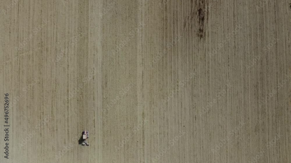 Aerial top down red tractor plowing organic soil in agricultural farm, minimalist drone view Aerial top down red tractor plowing organic soil in agricultural farm, minimalist drone view