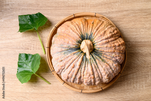 Asian pumpkin with leaf on wooden background